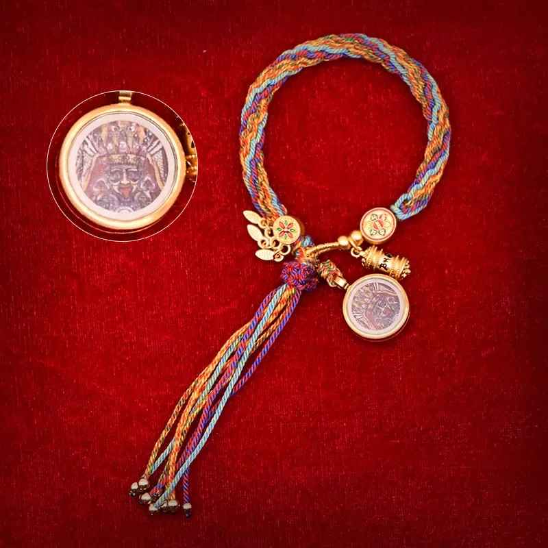 Pendentif doré finement sculpté rappelant un mantra spirituel.