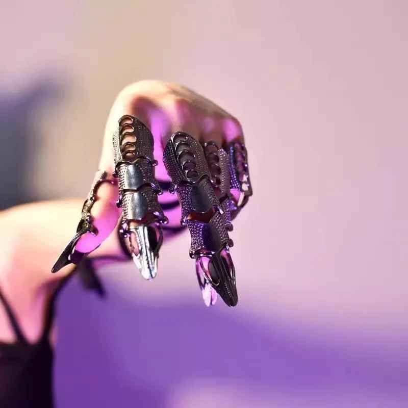 Doigt armure en métal argenté avec reliefs futuristes et forme agressive.