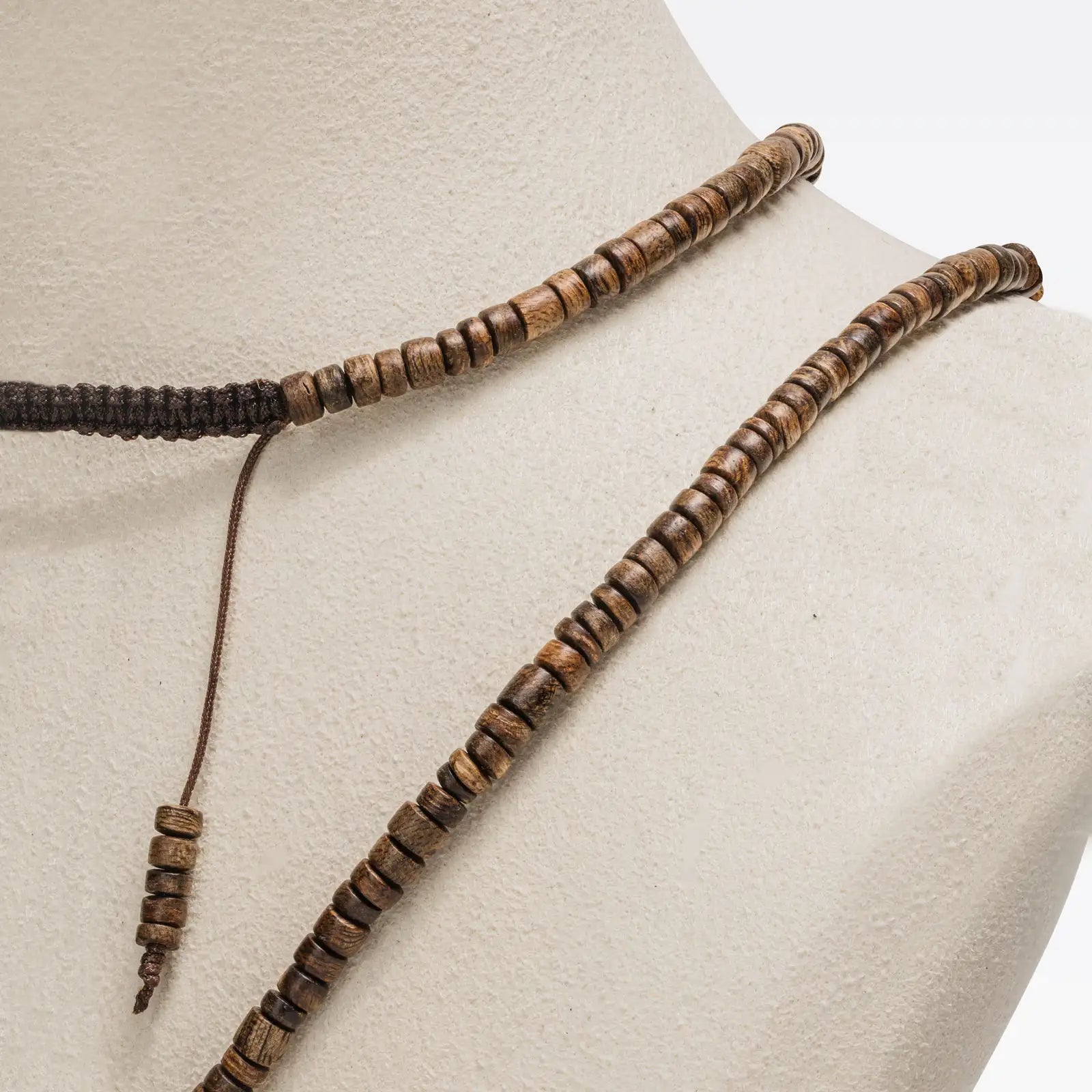 Enfilage de perles disque en bois d’agar, avec variations naturelles de veinage.