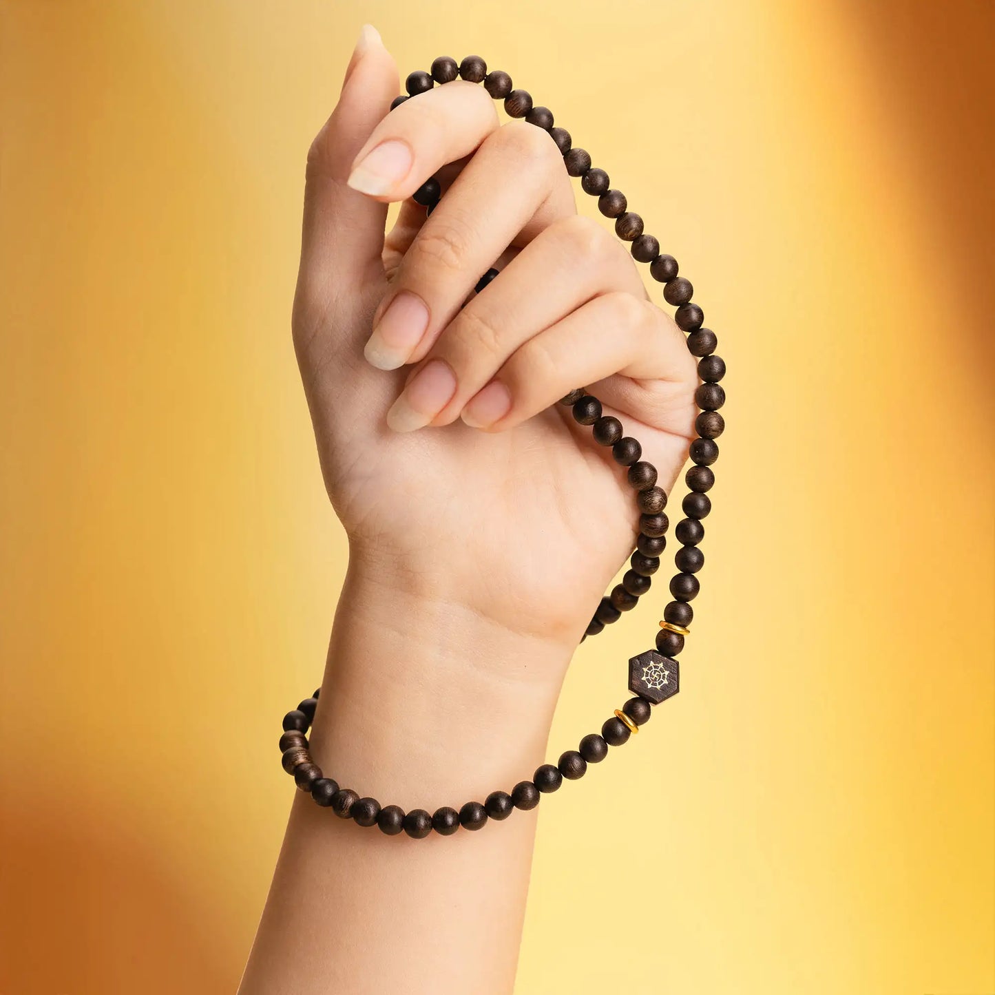 Détail du collier en bois d’agar mettant en valeur la structure des perles.