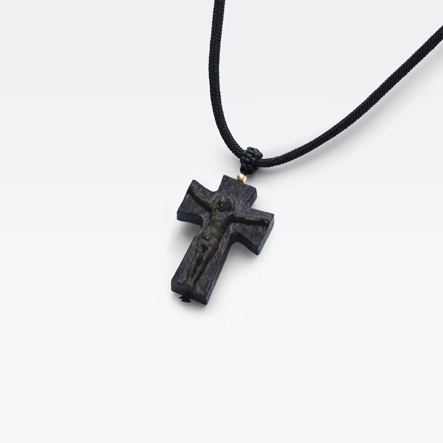 Collier avec croix sculptée en bois d’agar naturel et cordon textile ajustable.