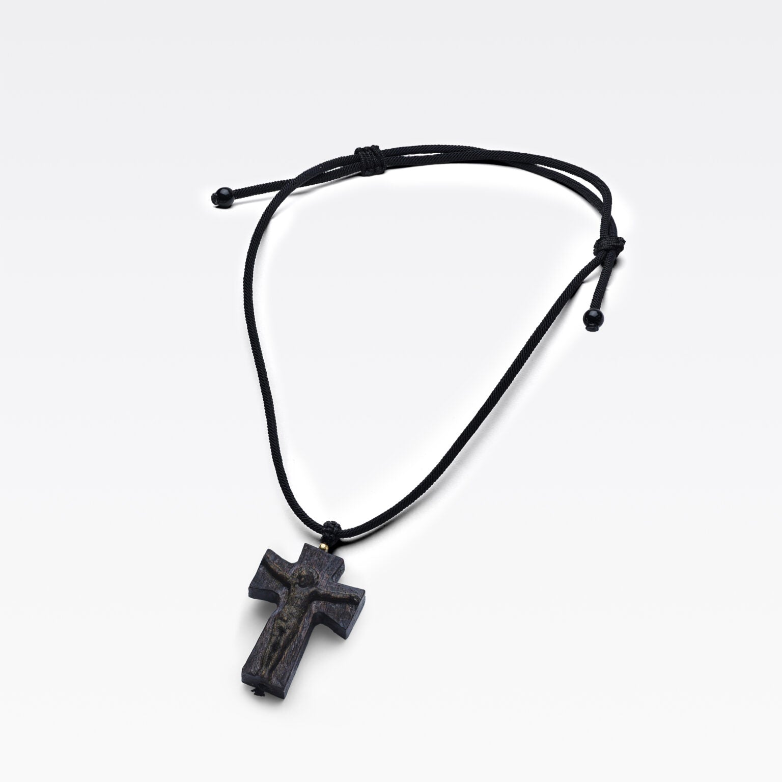 Grain naturel du bois d’agar révélé sur une croix sculptée.