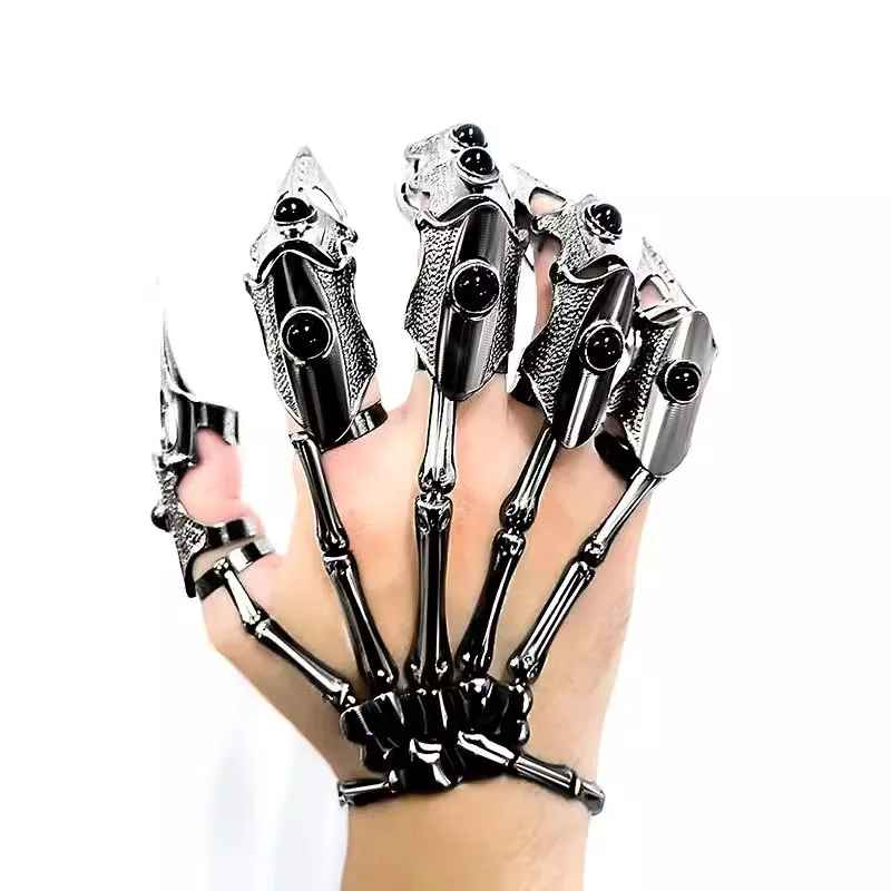 Griffes métalliques articulées de style cyberpunk portées sur les doigts avec reflets argentés.