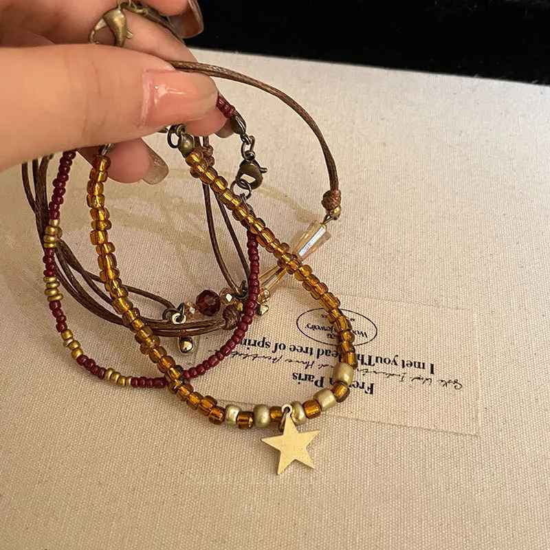 Détail des perles marron et du pendentif étoile dorée sur bracelet rétro.