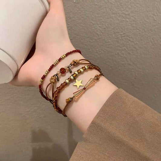 Bracelet rétro en perles de cristal marron et bordeaux posé sur tissu clair.