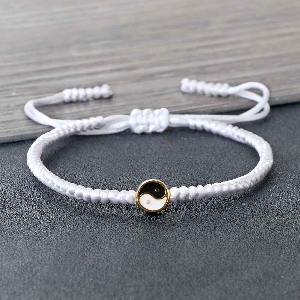 Médaillon Taiji noir et blanc au centre du bracelet, pensé comme un repère d’harmonie.