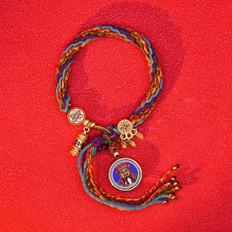 Breloque ronde inspirée d’un attrape-rêves sur bracelet coloré.