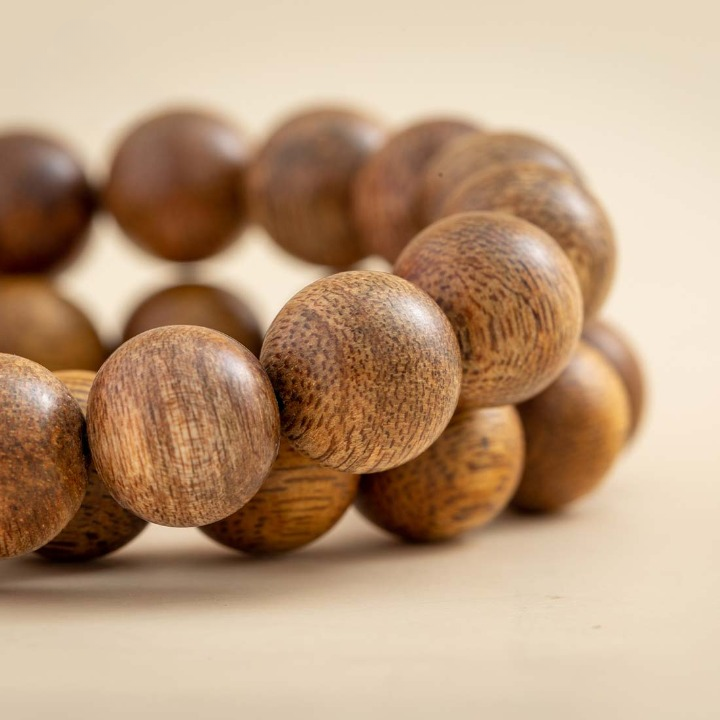 Perles sphériques en bois d’agar aux nuances naturelles.